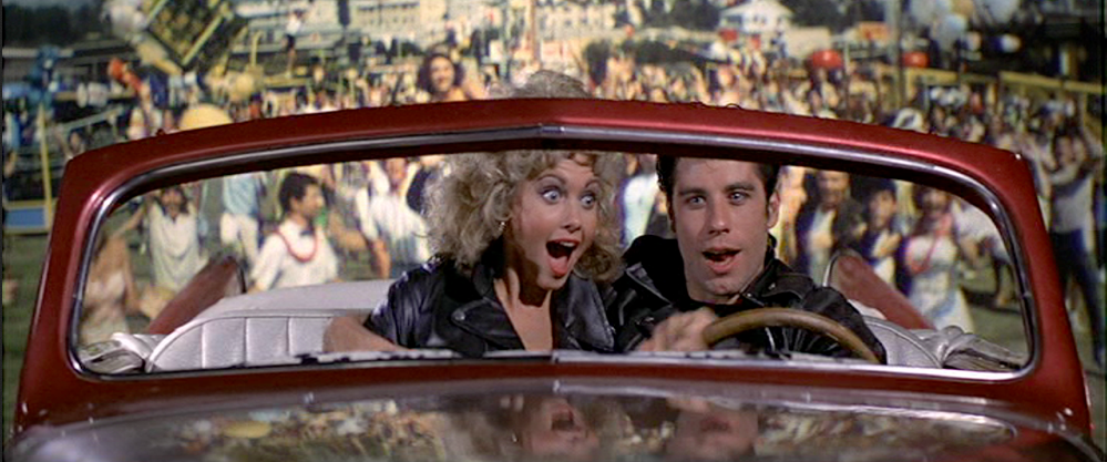 Sandy Olsson & Danny Zuko in Grease in Red Car