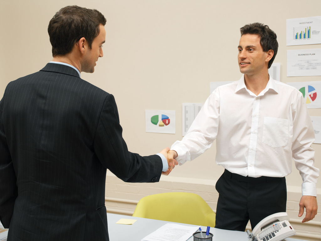 Two men shaking hands at work