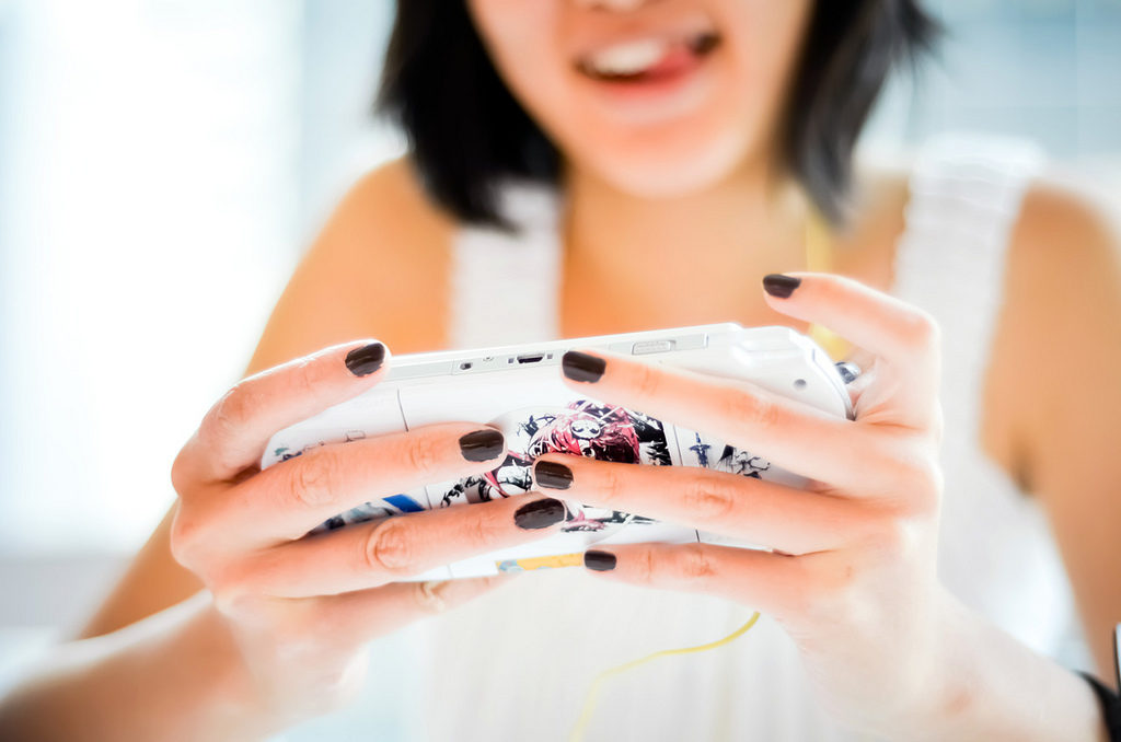 Woman playing a PlayStation Portable (PSP)