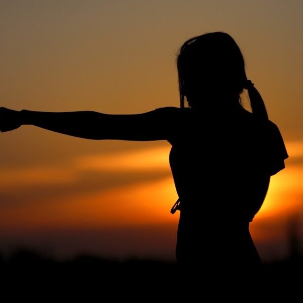 Silhouette of woman training at sunrise