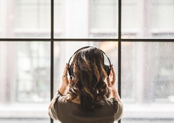 Woman wearing headphones looking out of a window