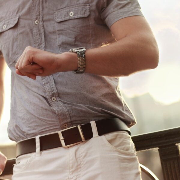 Watch on the wrist of a man leaning on a railing