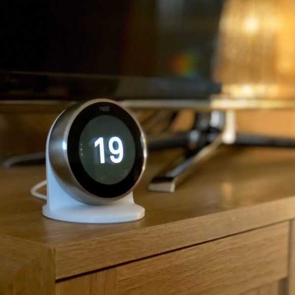 Nest Learning Thermostat installed on the Nest Stand on a TV cabinet
