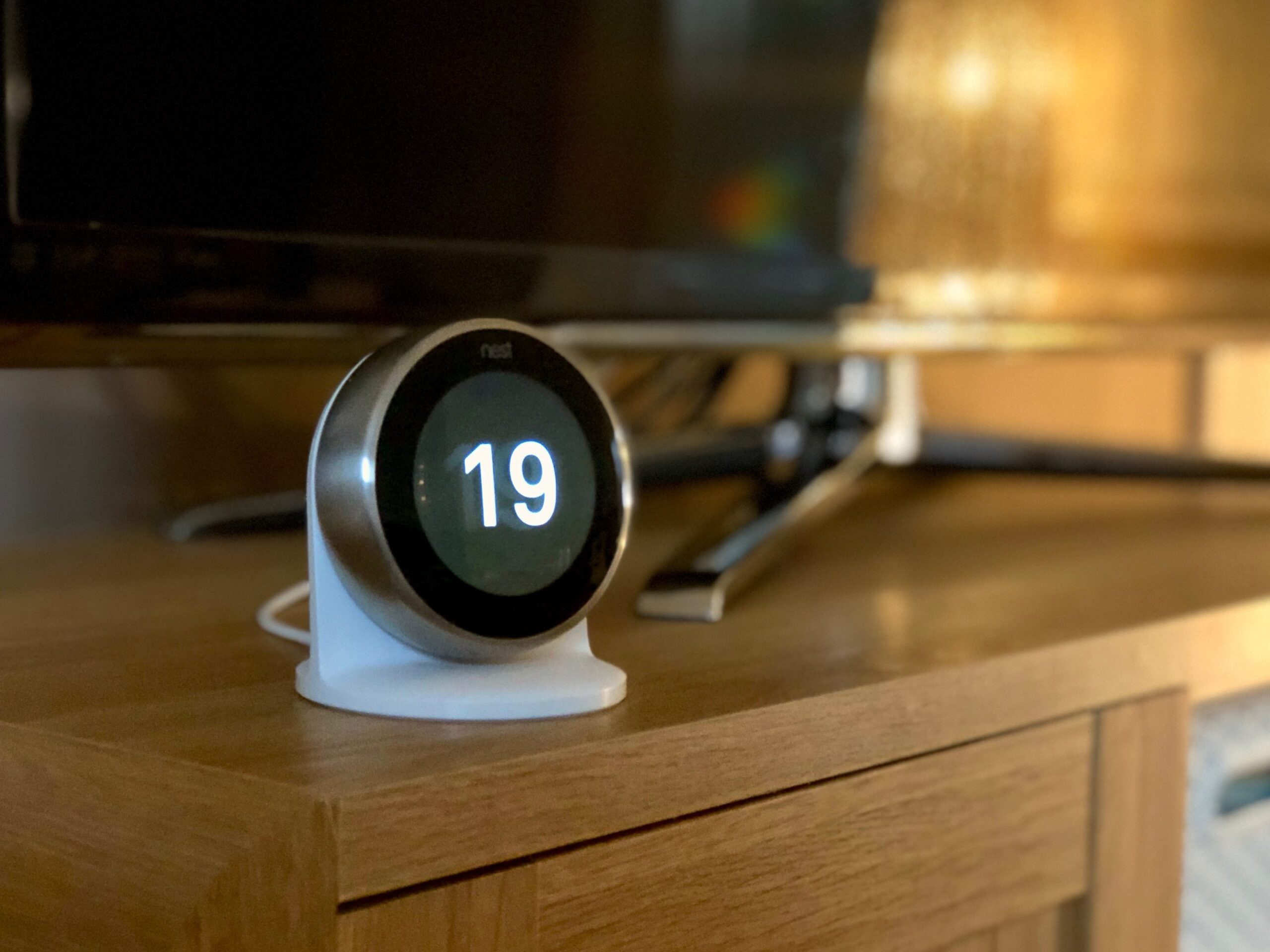 Nest Learning Thermostat installed on the Nest Stand on a TV cabinet