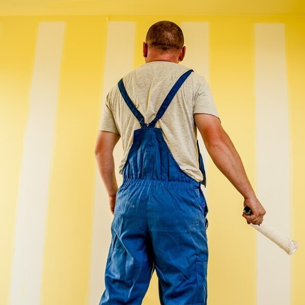 House painter in front of a yellow wall