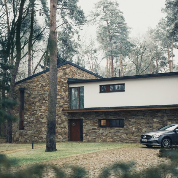 House surrounded by trees with a car