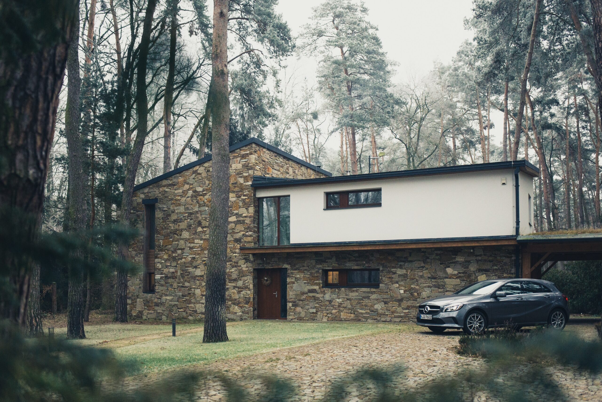 House surrounded by trees with a car
