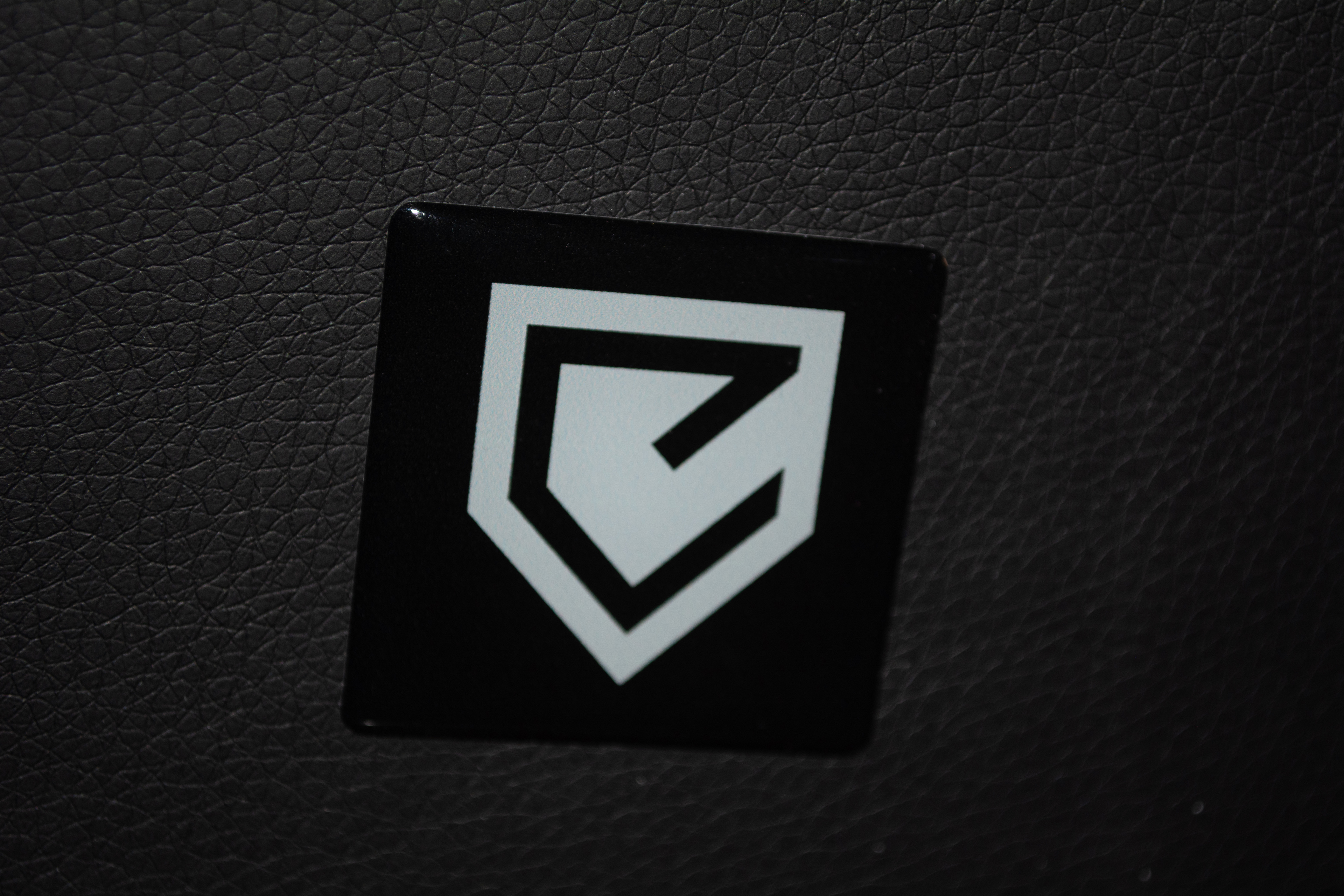 Closeup of badge on the rear of the EDGE GX1 gaming chair's headrest