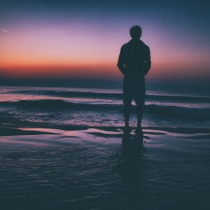 Man standing on beach at sunset