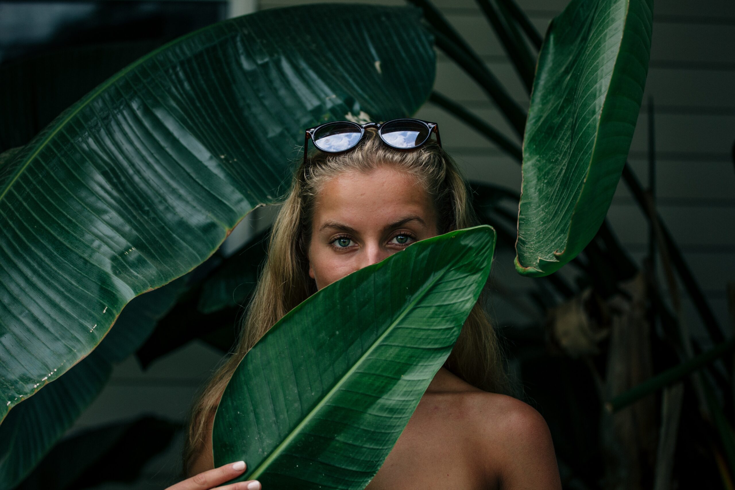 Woman hiding behind leaf