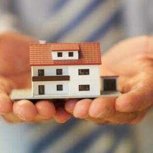 Hands holding a model of a house