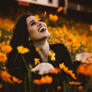 Woman smiling surrounded by flowers