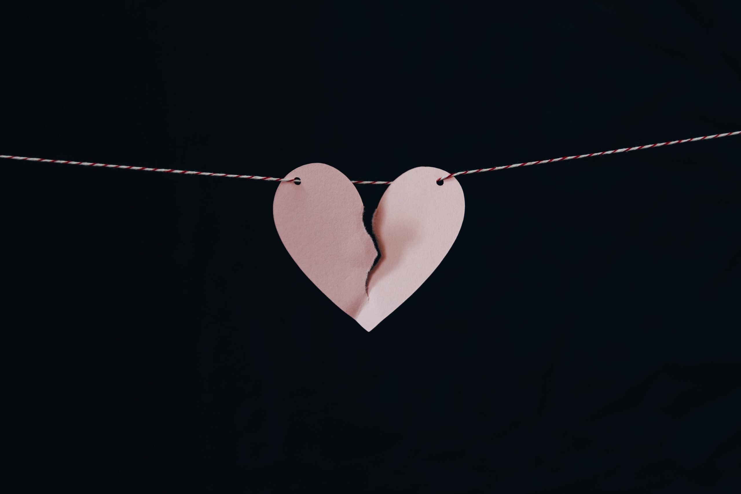 Broken heart hanging on a wire