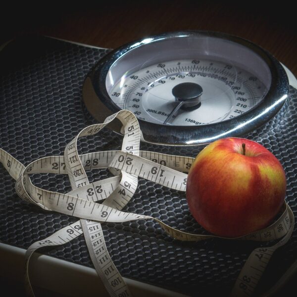 Tape measure and apple on scales