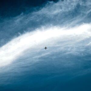 Plane silhouette among clouds