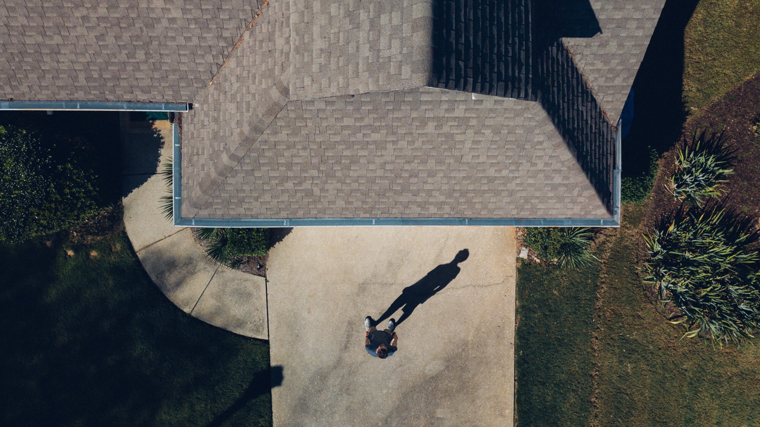 Aerial view of a roof and a man in front of house