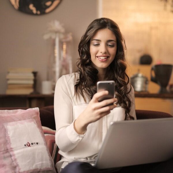 Woman using a smartphone and laptop