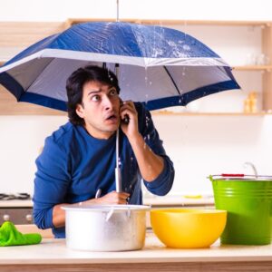 Man under umbrella using a phone indoors