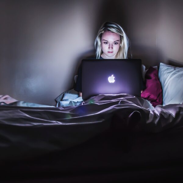 Woman using MacBook in bed