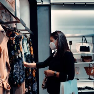 Woman shopping for clothes whilst wearing a face mask