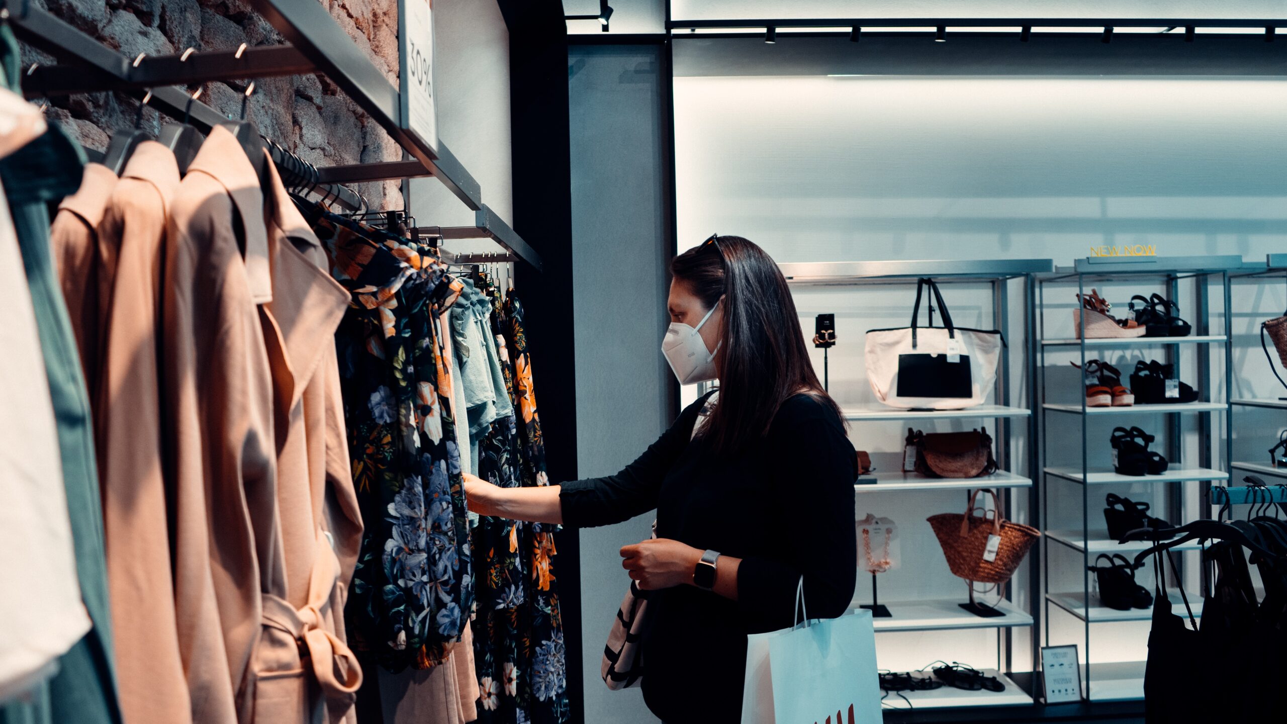 Woman shopping for clothes whilst wearing a face mask