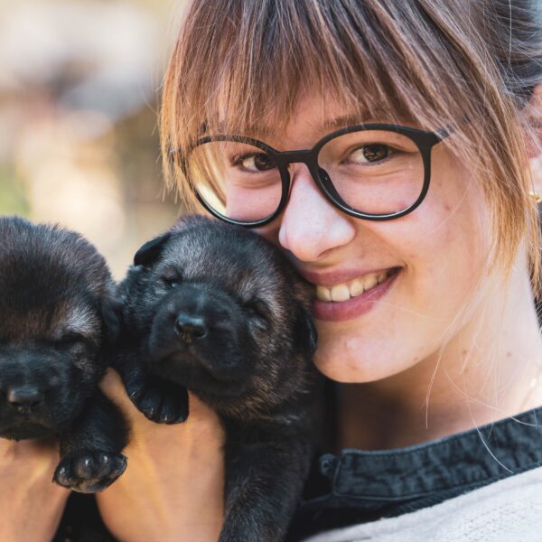 Woman holding two puppies