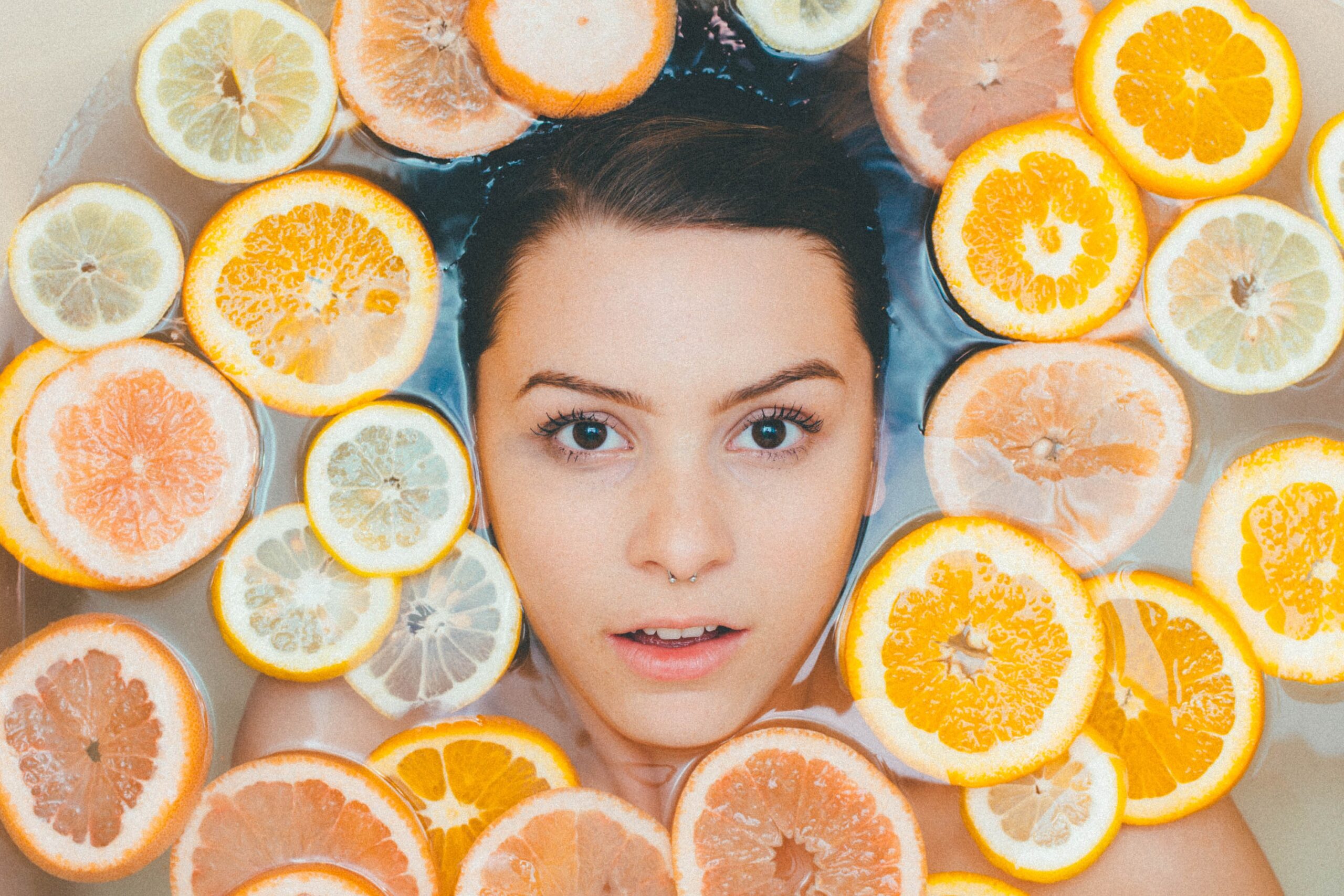 Woman in a bath tub of fruit