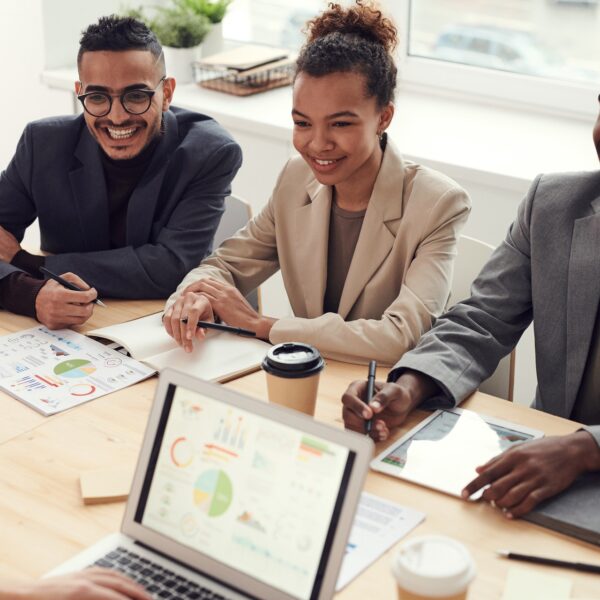 Photo of three people smiling while having a meeting