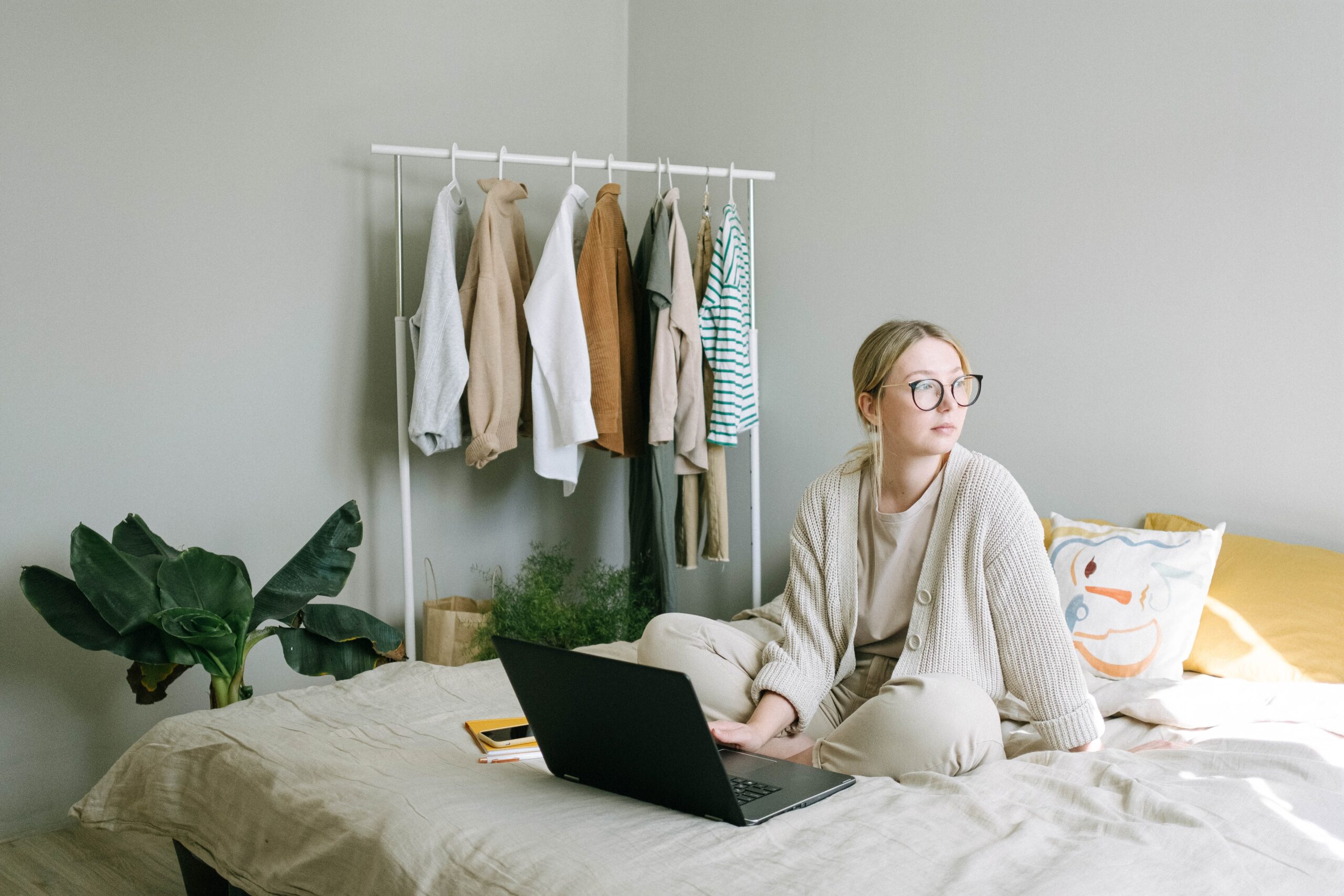 Woman in a sweater using a laptop on bed