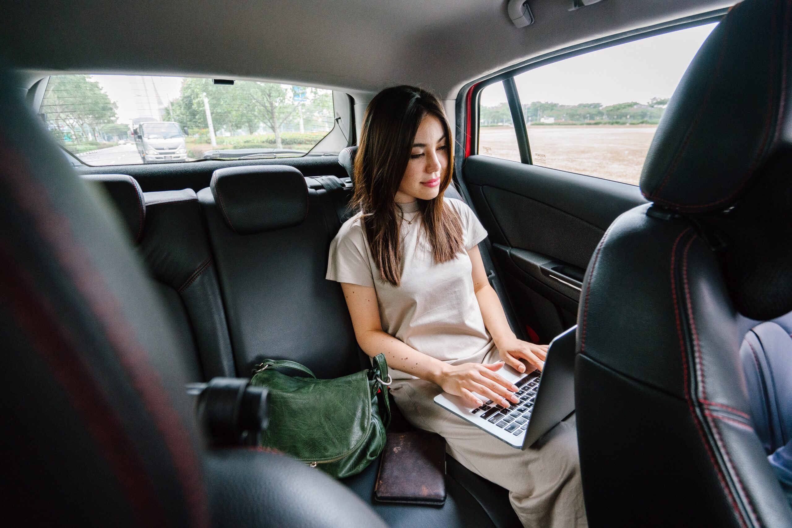 Woman using a laptop in a car