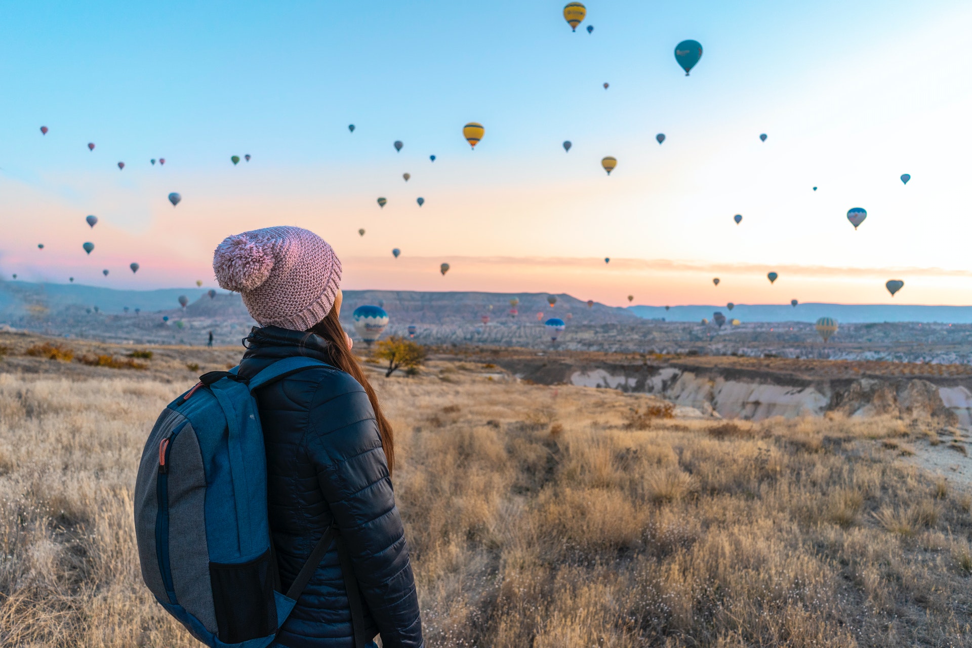 Woman watching hot air balloons rise into the air