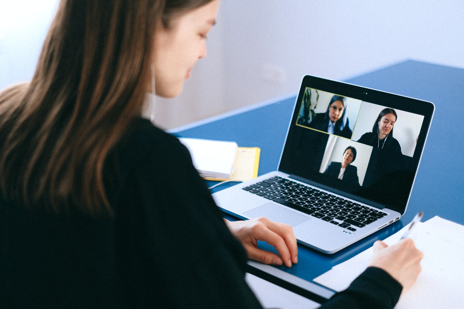 A woman on a video call with three other women