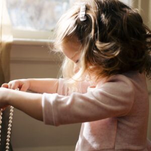 Little girl holding a necklace