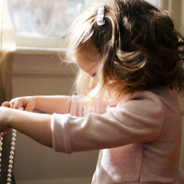 Little girl holding a necklace