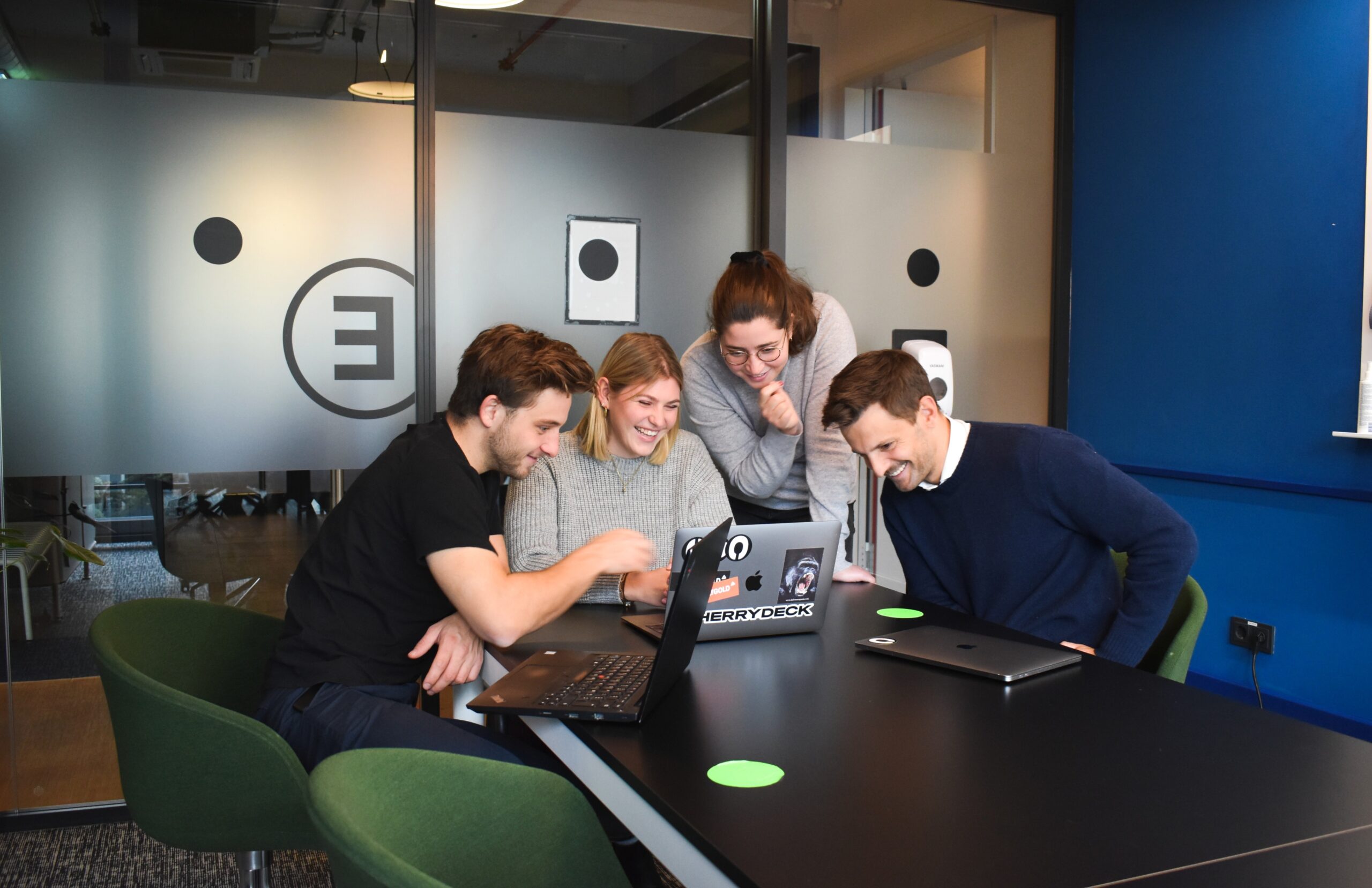 Group of people smiling at a laptop