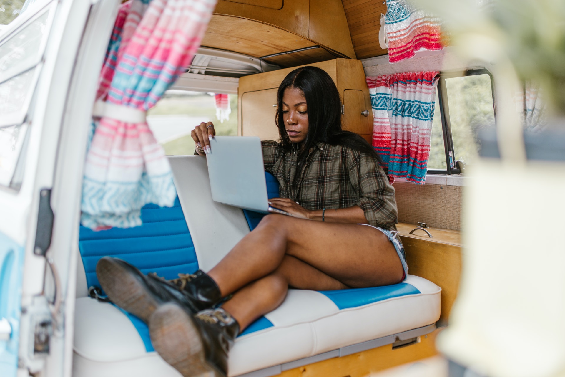 Woman using a laptop in the back of a camper van