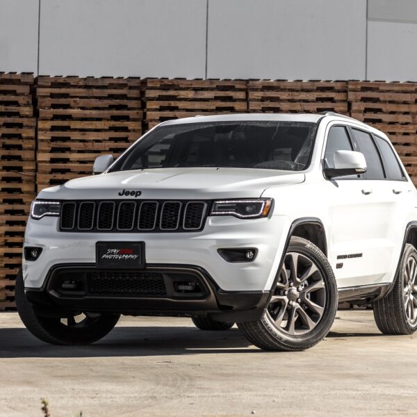 White Jeep Cherokee SUV near stacked brown pallet boards