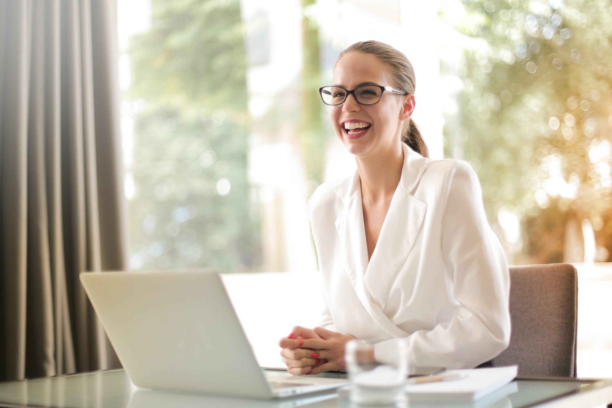 Businesswoman laughing in front of a laptop