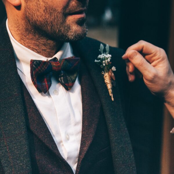 Man wearing a bowtie and buttonhole flowers