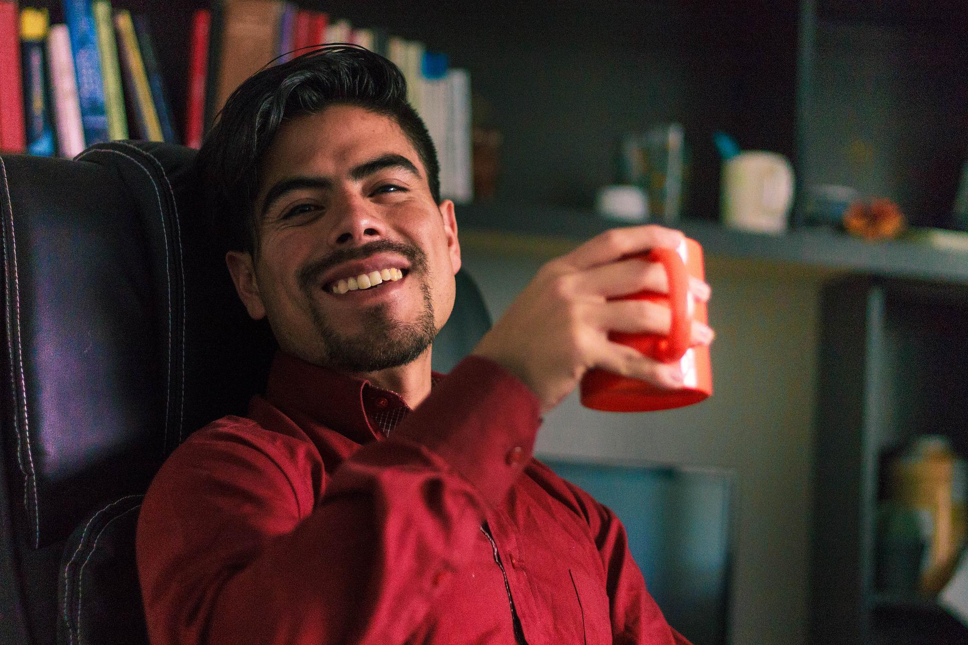 Man smiling whilst holding a mug