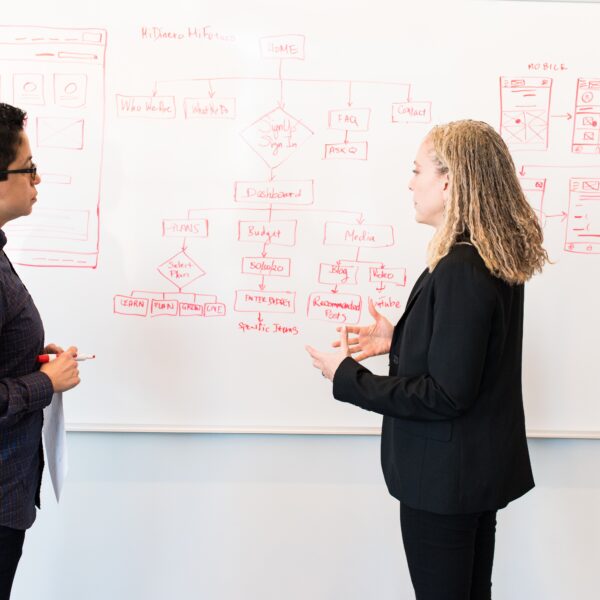 Two women standing in front of a whiteboard