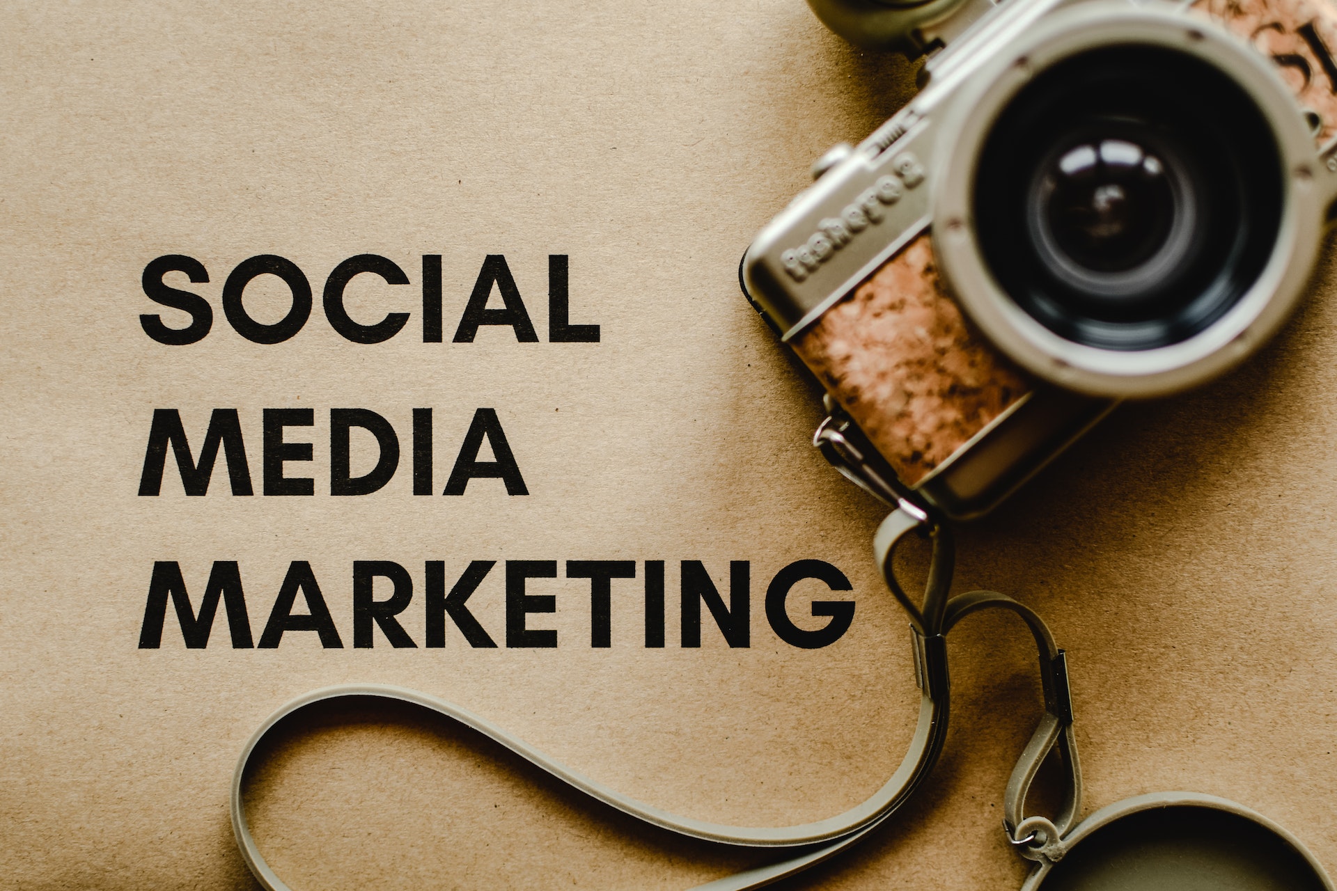 Didital camera next to the words "social media marketing" printed on brown paper