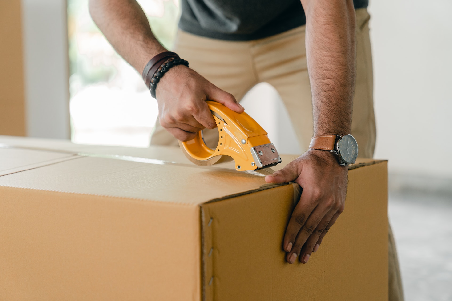 Man taping up a cardboard box