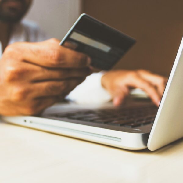 Man using a debit card to buy something on his laptop