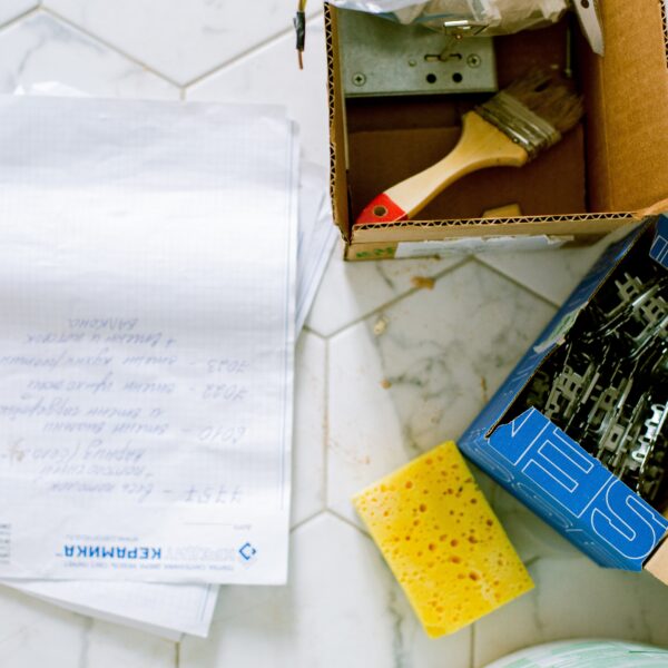 Papers, sponge and boxes of decorating supplies on a tiled floor