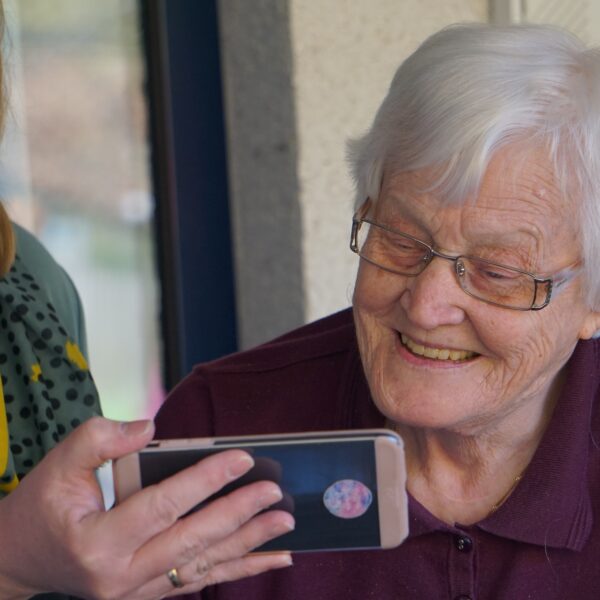 An elderly woman and a carer looking at a mobile phone