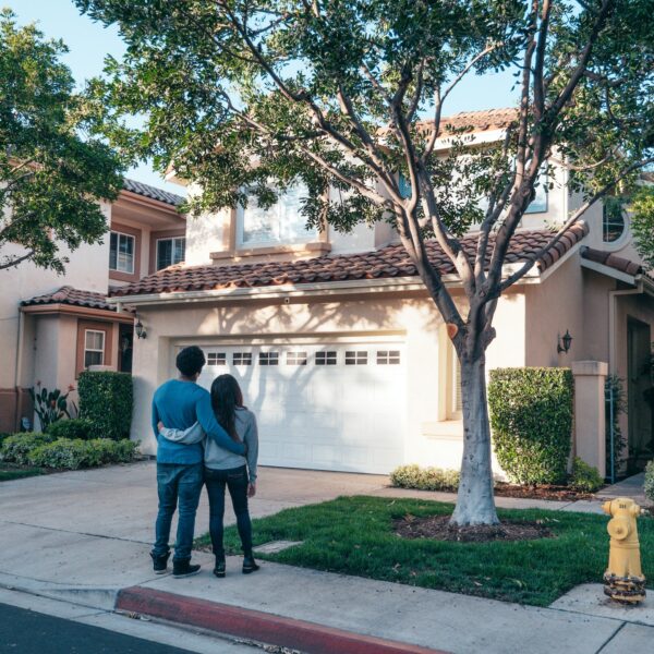 Couple standing in front of their house