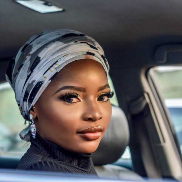 Photo of Woman Wearing White and Black Floral Headscarf Inside Car