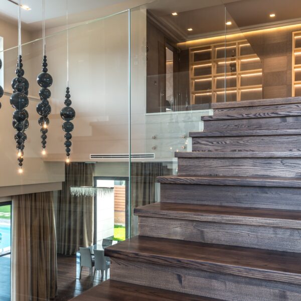 Brown wooden staircase with glass railing
