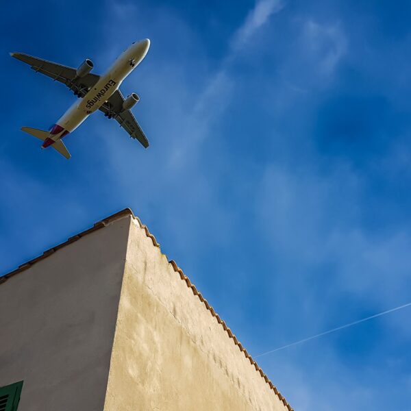 Airplane flying overhead above a building